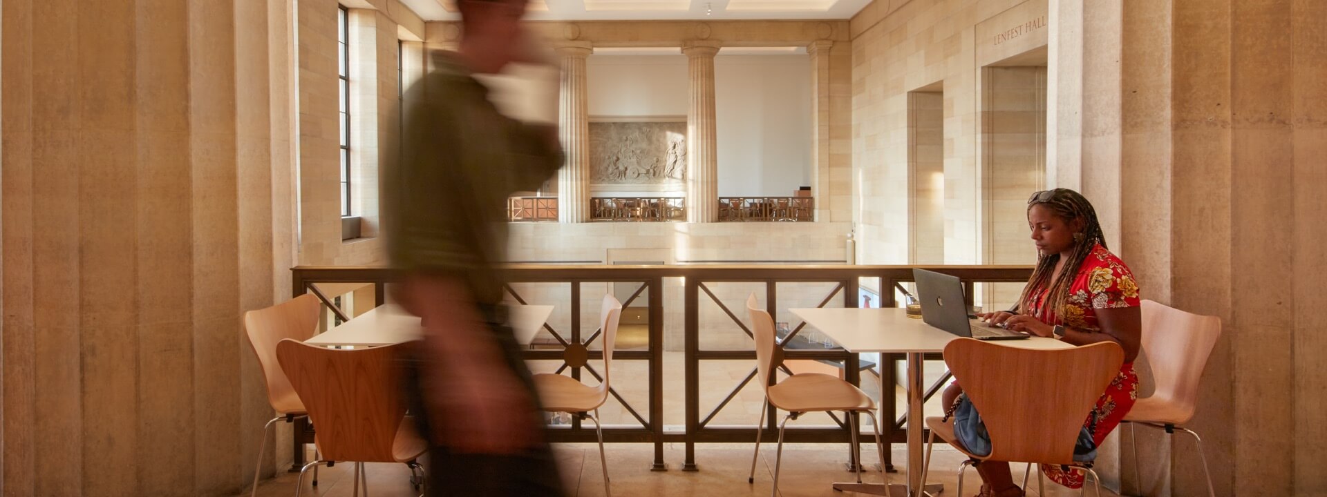 A woman seated and working on her laptop in the Balcony Cafe